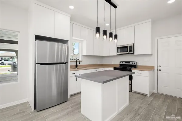 a kitchen with stainless steel appliances a refrigerator stove and microwave