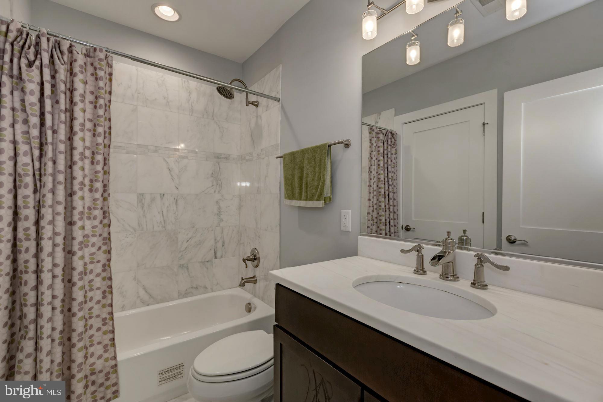 1202 Fairmont Street Northwest, Unit 2 Washington, DC 20009 - Photo 15 of 26 Dual-entry white marble 2nd/guest bath