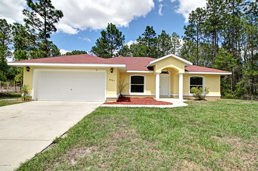 8985 Southwest 133rd Ln Road Ocala, FL 34473 - Photo 1 of 1 a front view of a house with a yard and garage