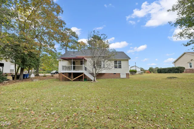 a view of a house with backyard and trees