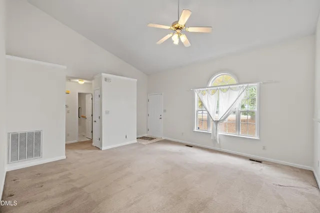 an empty room with windows and fireplace