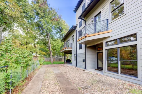 a view of a house with a yard and potted plants