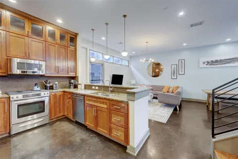 a large kitchen with stainless steel appliances granite countertop a stove and a sink