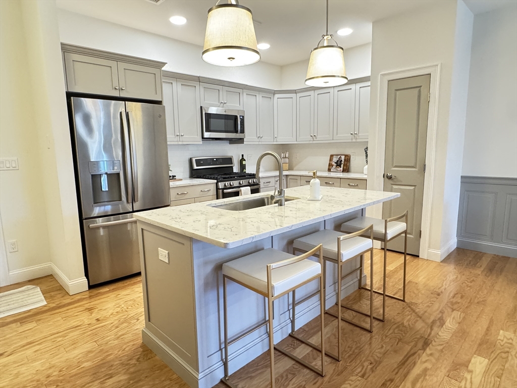 a kitchen with kitchen island granite countertop appliances cabinets and a counter top space