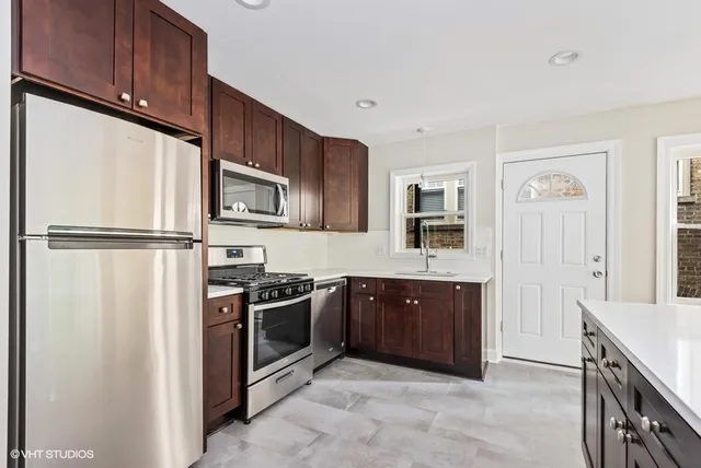 a kitchen with stainless steel appliances granite countertop a stove and a refrigerator