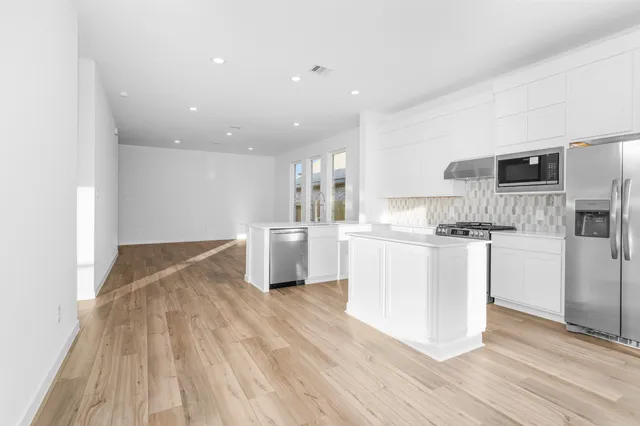 a kitchen with white cabinets and stainless steel appliances