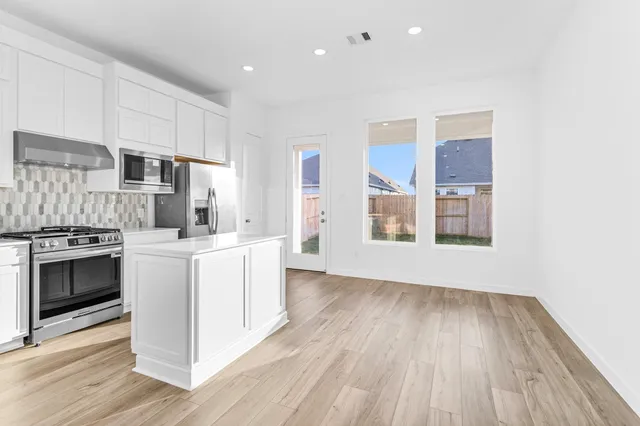 a kitchen with wooden floors and white appliances