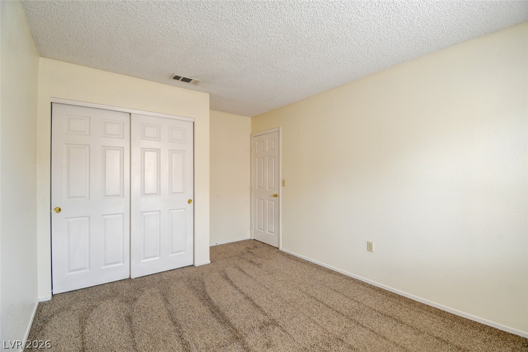 5 Tarryall Terrace Henderson, NV 89074 - Photo 26 of 44 A well-lit bedroom features plush carpeting and convenient closet storage.