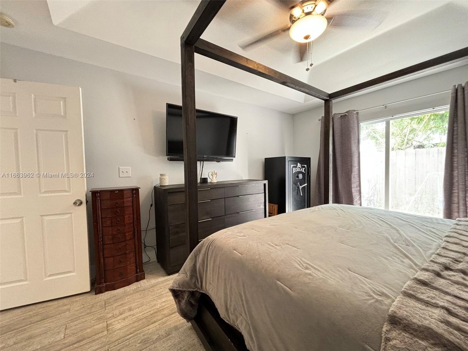 14170 Southwest 151st Avenue Miami, FL 33196 - Photo 21 of 23 a bedroom with a bed and a flat tv screen on dresser