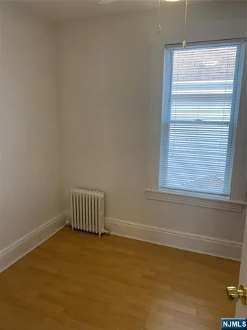 a room with a wooden floor and a window