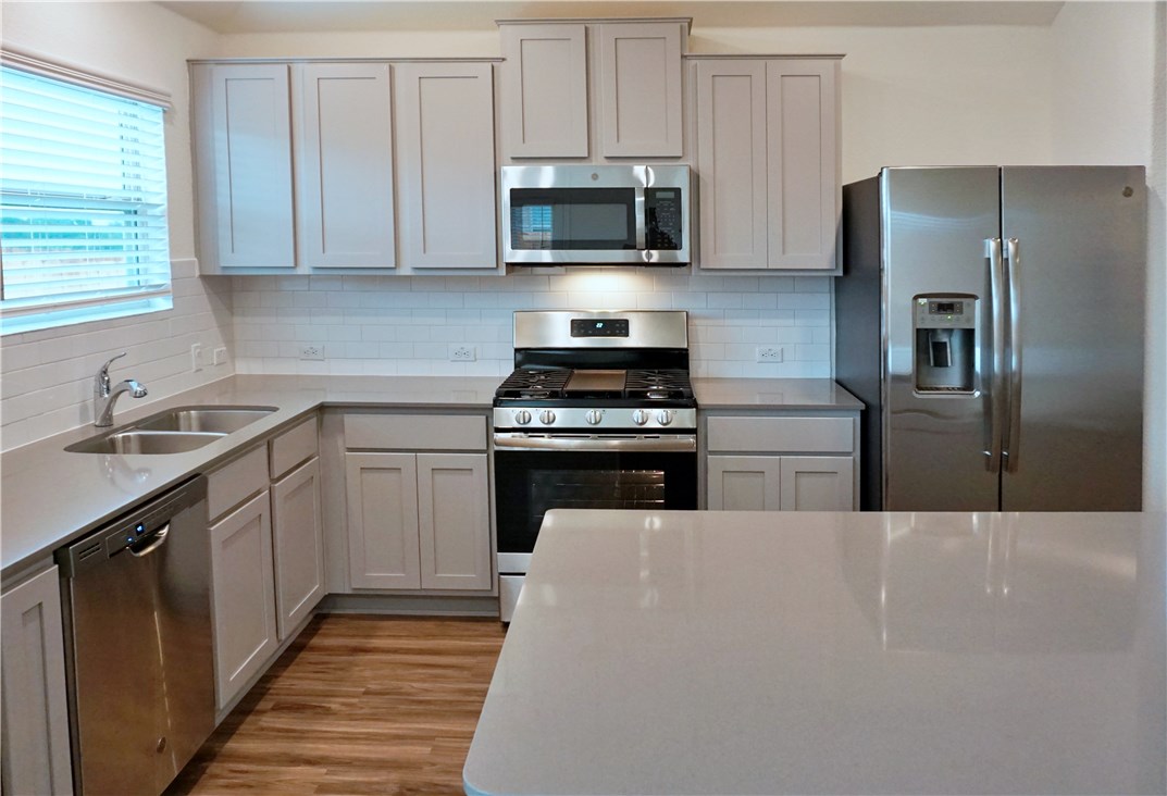 3493 Pauling Loop Round Rock, TX 78665 - Photo 5 of 19 a kitchen with cabinets stainless steel appliances and a window