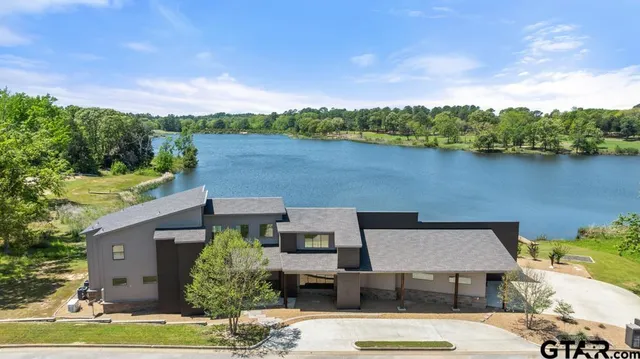 an aerial view of a house with a garden and lake view