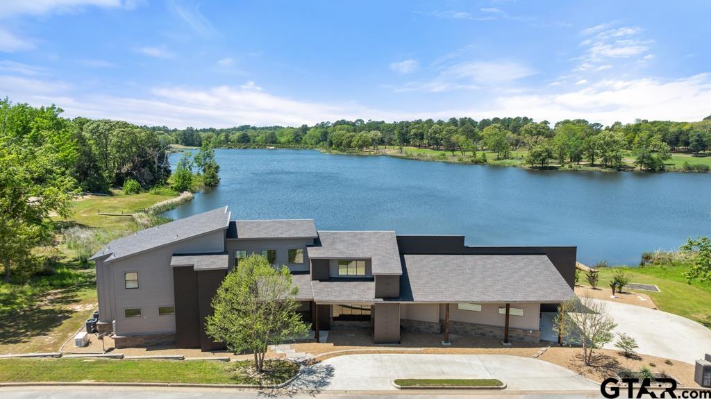 an aerial view of a house with a garden and lake view