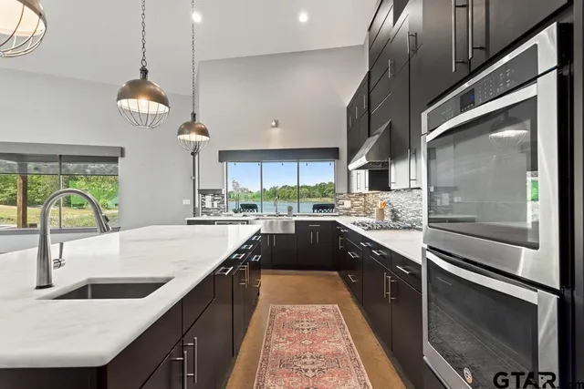 a large kitchen with granite countertop a stove and a sink