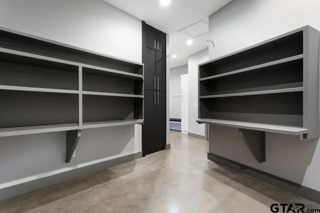 a view of walk in closet with empty racks