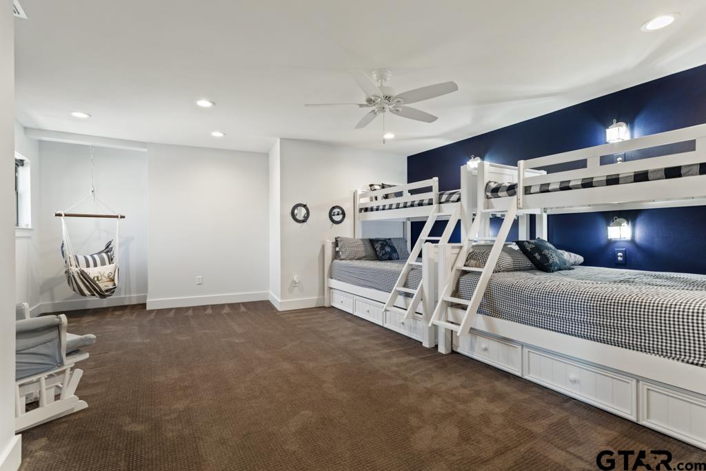 24116 Sun Ridge Road Lindale, TX 75771 - Photo 29 of 47 a spacious bedroom with a bed and a chandelier