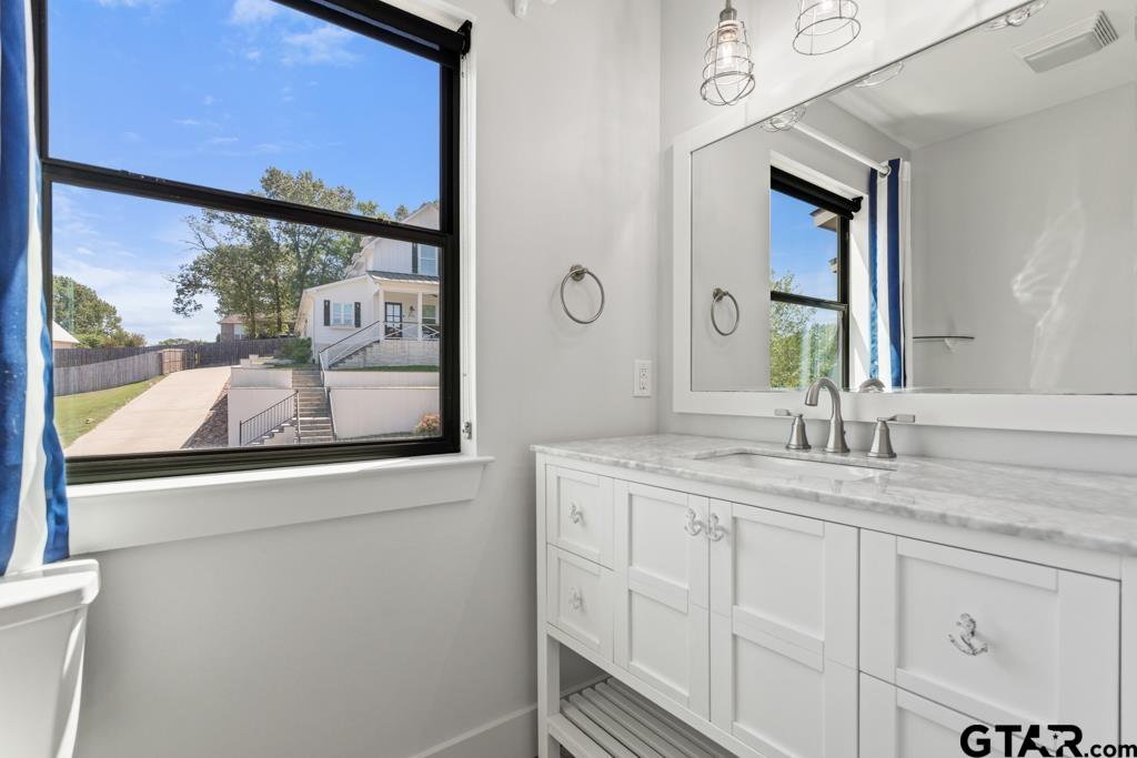24116 Sun Ridge Road Lindale, TX 75771 - Photo 32 of 47 a bathroom with a granite countertop sink mirror and vanity