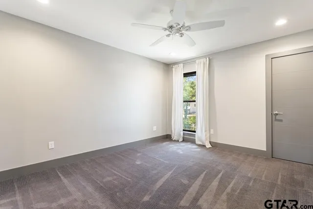 an empty room with a chandelier fan and closet