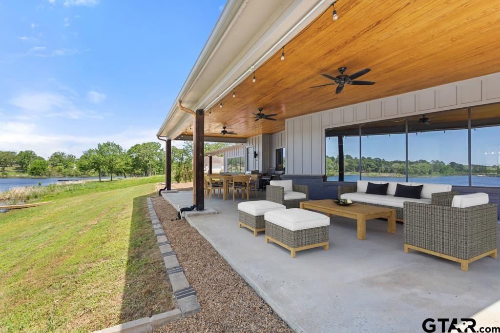 24116 Sun Ridge Road Lindale, TX 75771 - Photo 40 of 47 a living room with patio furniture and a lake view