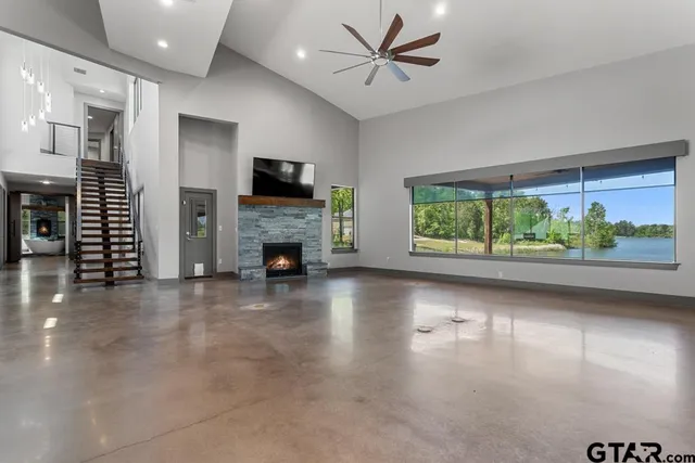 a view of a livingroom with furniture a fireplace and window