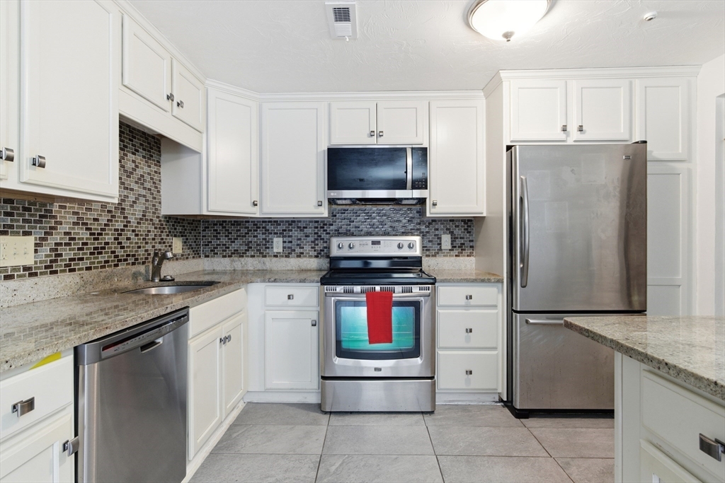a kitchen with stainless steel appliances granite countertop a refrigerator stove and sink
