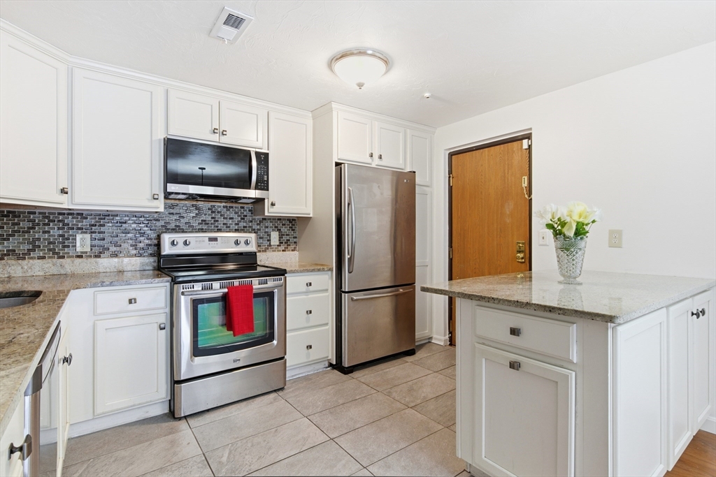 356 Neponset Street, Unit E Canton, MA 02021 - Photo 14 of 22 a kitchen with stainless steel appliances white cabinets and a stove top oven
