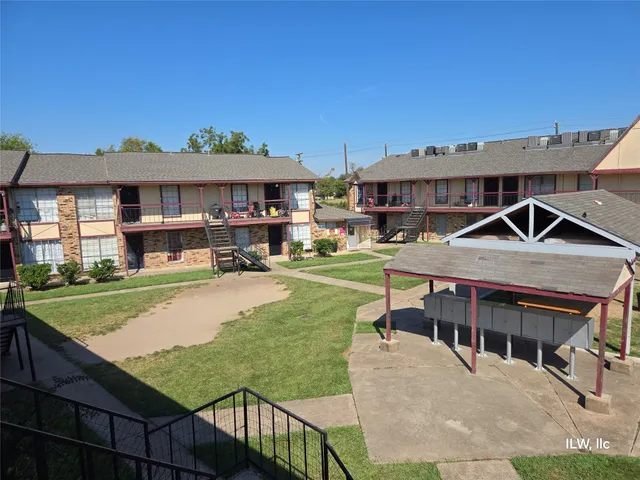 a view of a patio with table and chairs under an umbrella