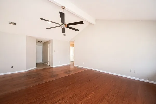 a view of empty room with wooden floor