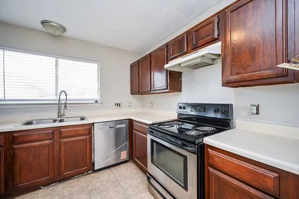 a kitchen with stainless steel appliances granite countertop a sink stove and cabinets