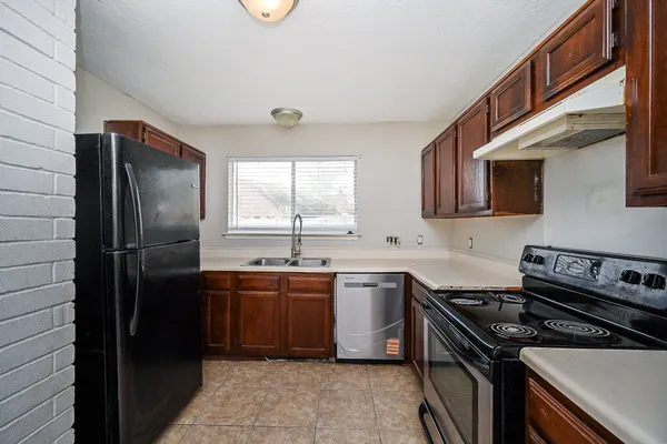 a kitchen with stainless steel appliances a sink stove and refrigerator