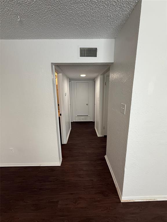 1715 Short Street, Unit D Cleburne, TX 76033 - Photo 3 of 12 Hallway featuring dark wood-finish flooring, white baseboards, and white walls