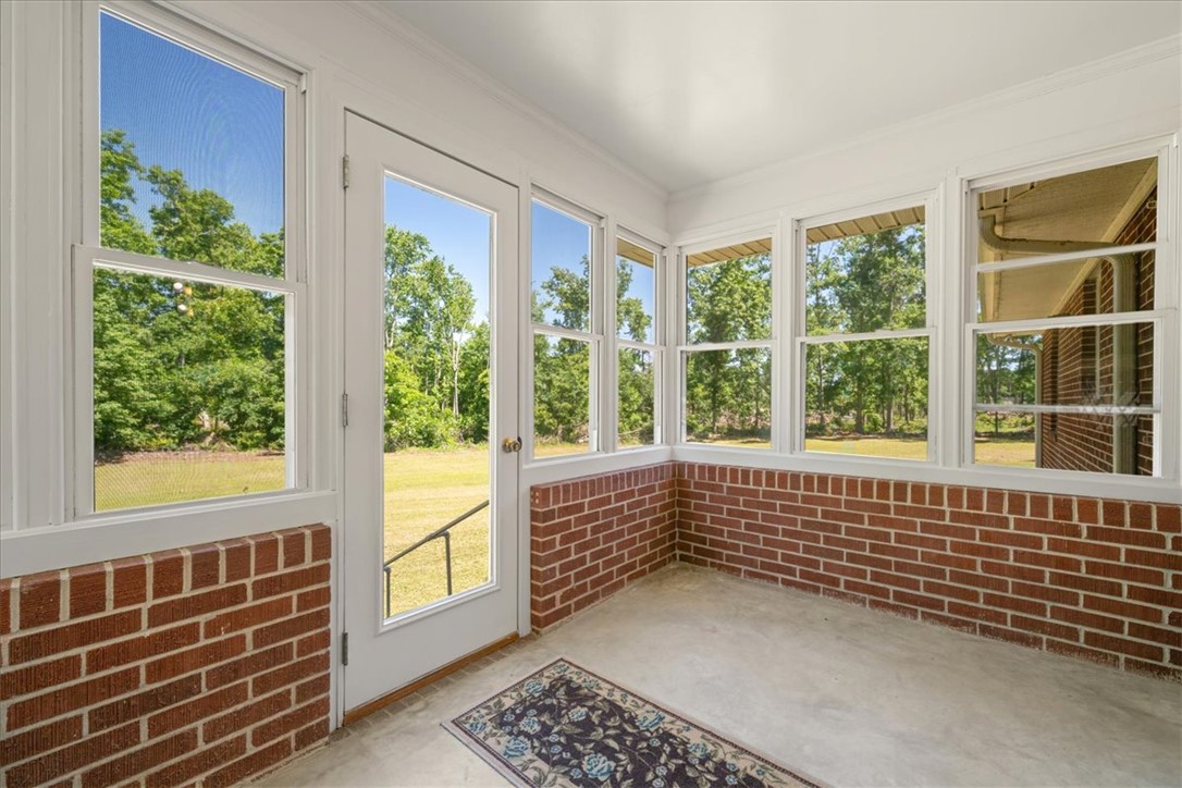 304 Shaw Road Honea Path, SC 29654 - Photo 10 of 39 This bright sunroom offers expansive views of the outdoors, seamlessly blending indoor comfort with natural beauty.