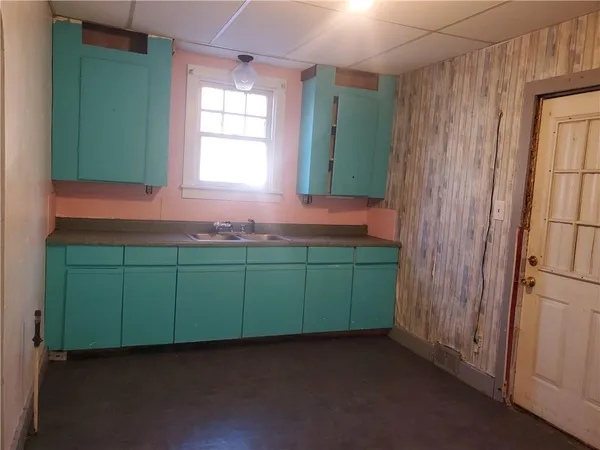 a room with green cabinets and a window