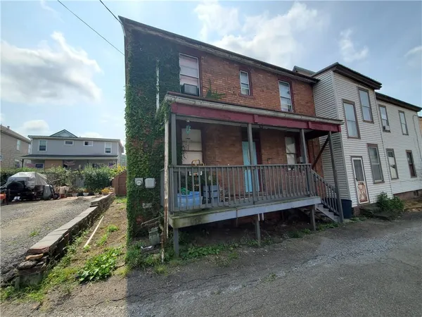 a view of wooden house with a yard