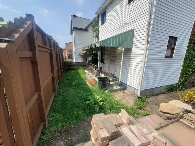 a view of backyard of house and patio