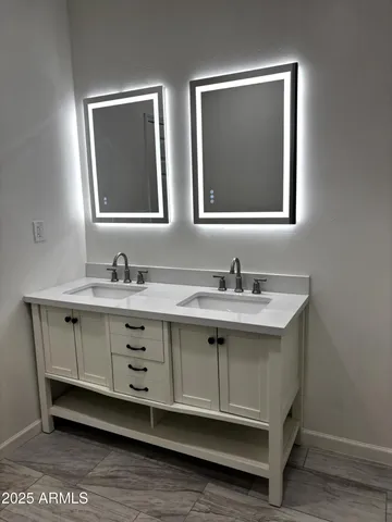 a bathroom with a double vanity sink and mirror