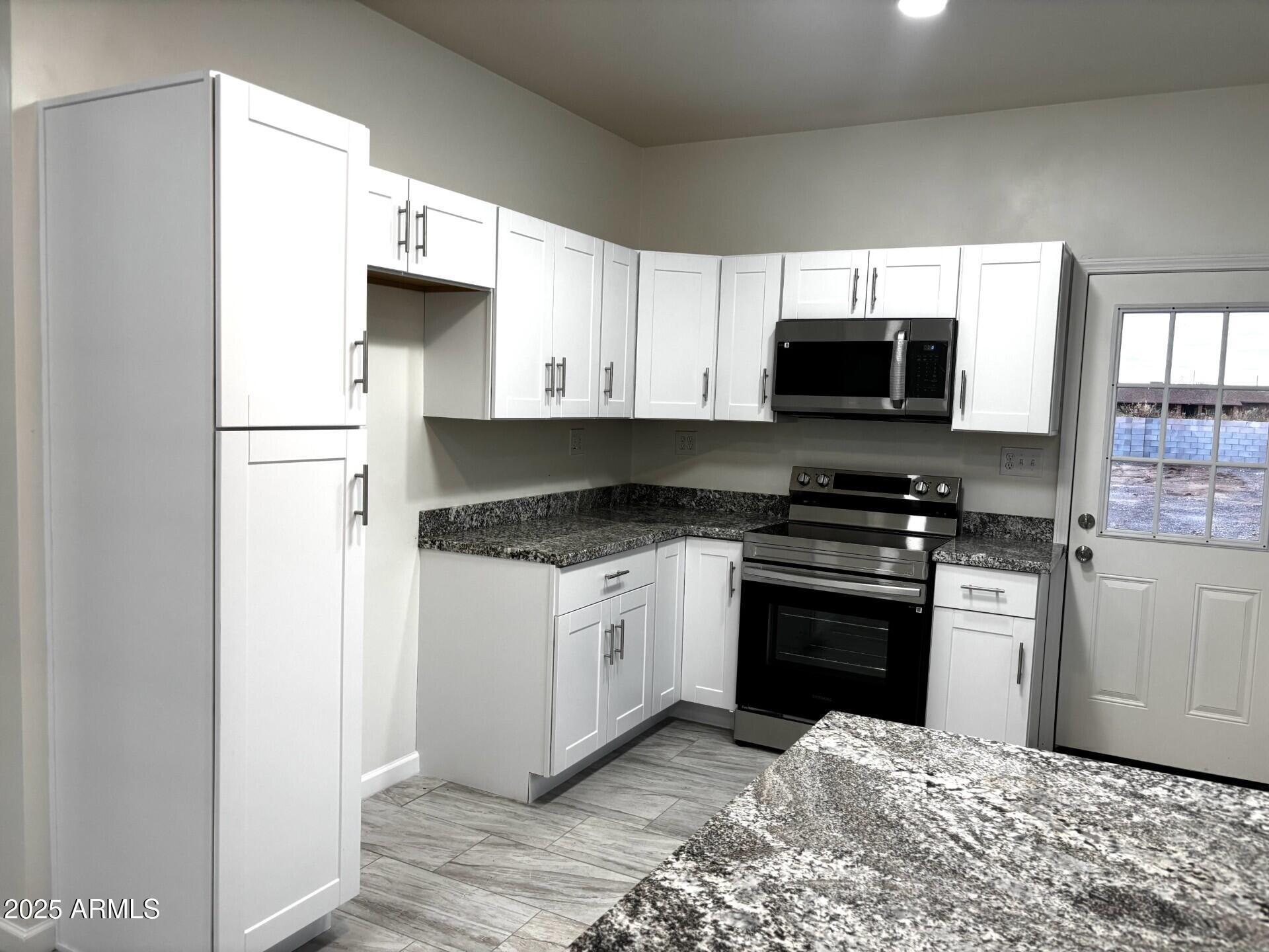 486 Anderson Avenue Douglas, AZ 85607 - Photo 2 of 16 a kitchen with a refrigerator stove and microwave