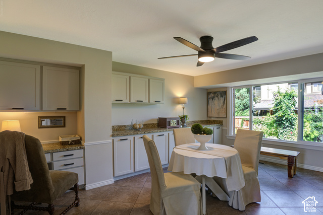 1933 Rua Branco Drive Sandy, UT 84093 - Photo 13 of 42 Built-in cabinetry with stone countertops, integrated workspace, and a ceiling fan with integrated lighting