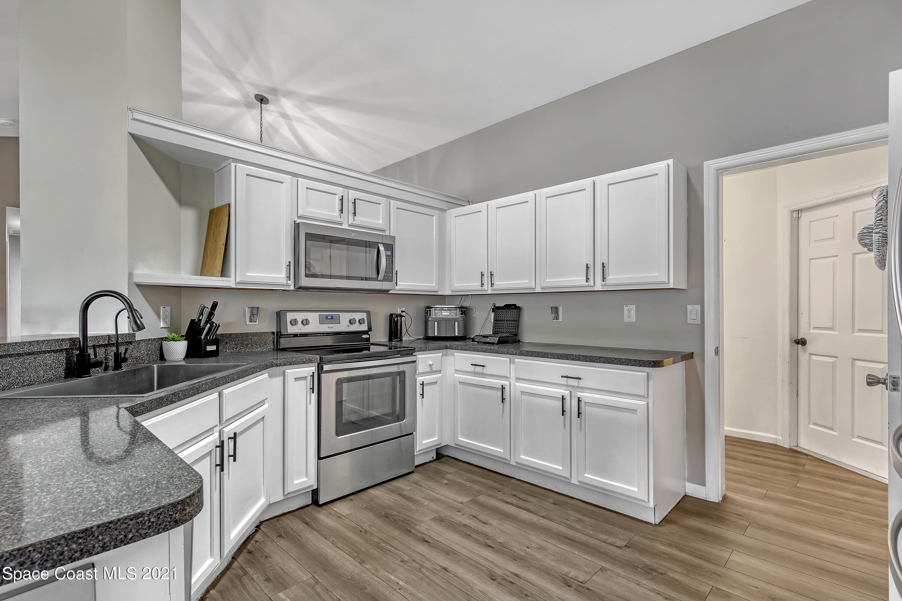 1277 Harlingen Road Southwest Palm Bay, FL 32908 - Photo 11 of 32 a kitchen with cabinets a sink and appliances