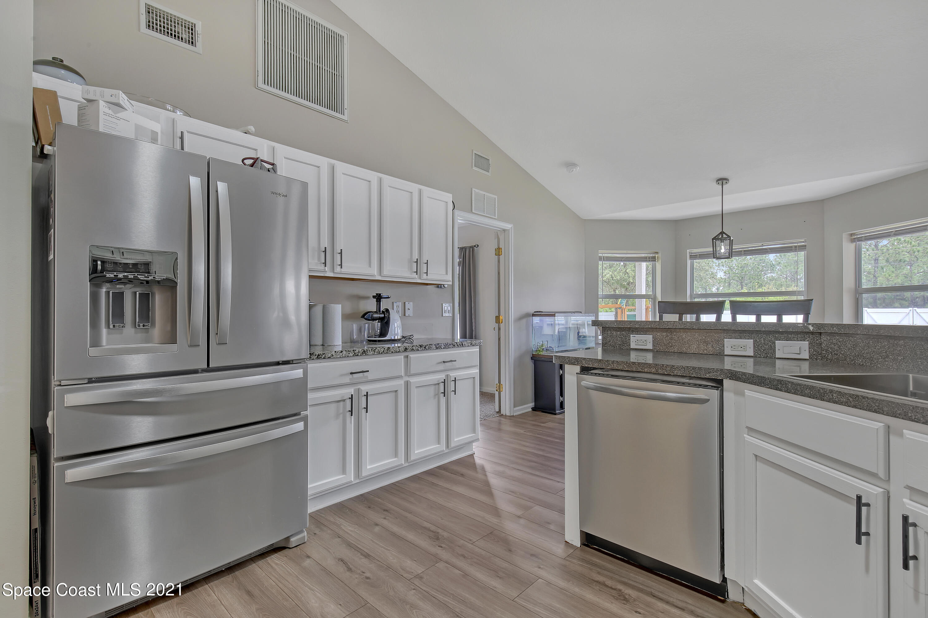 1277 Harlingen Road Southwest Palm Bay, FL 32908 - Photo 12 of 32 a kitchen with granite countertop white cabinets and stainless steel appliances