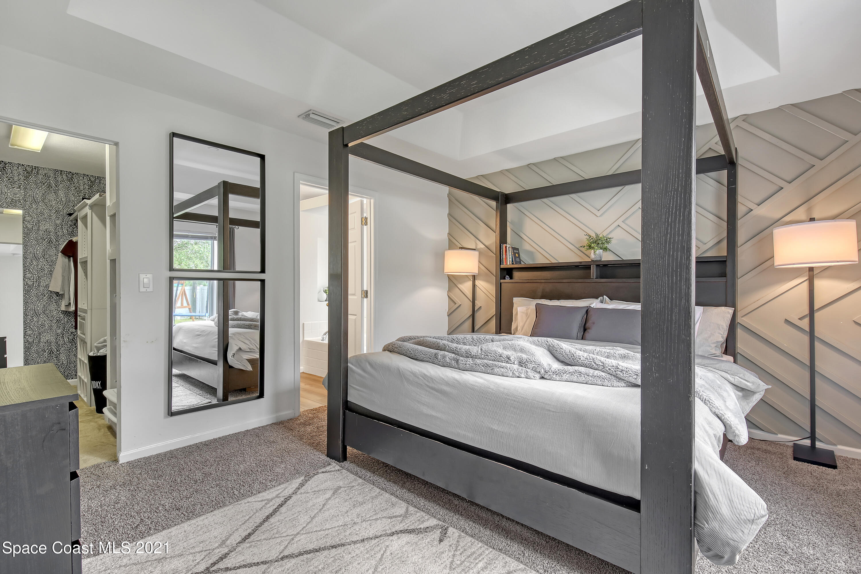 1277 Harlingen Road Southwest Palm Bay, FL 32908 - Photo 15 of 32 a large bedroom with a bed and glass door