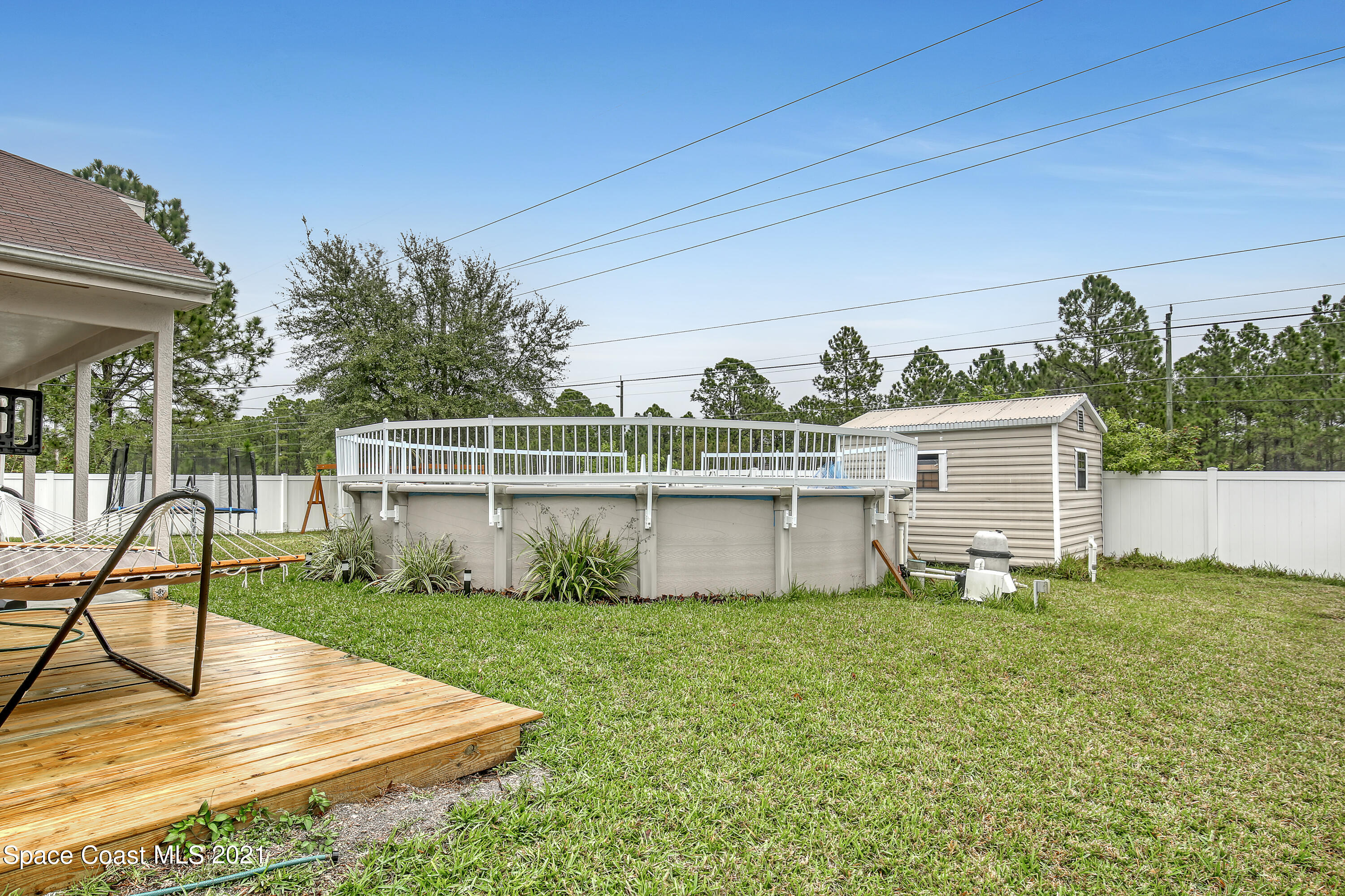 1277 Harlingen Road Southwest Palm Bay, FL 32908 - Photo 32 of 32 a view of a backyard with plants and deck