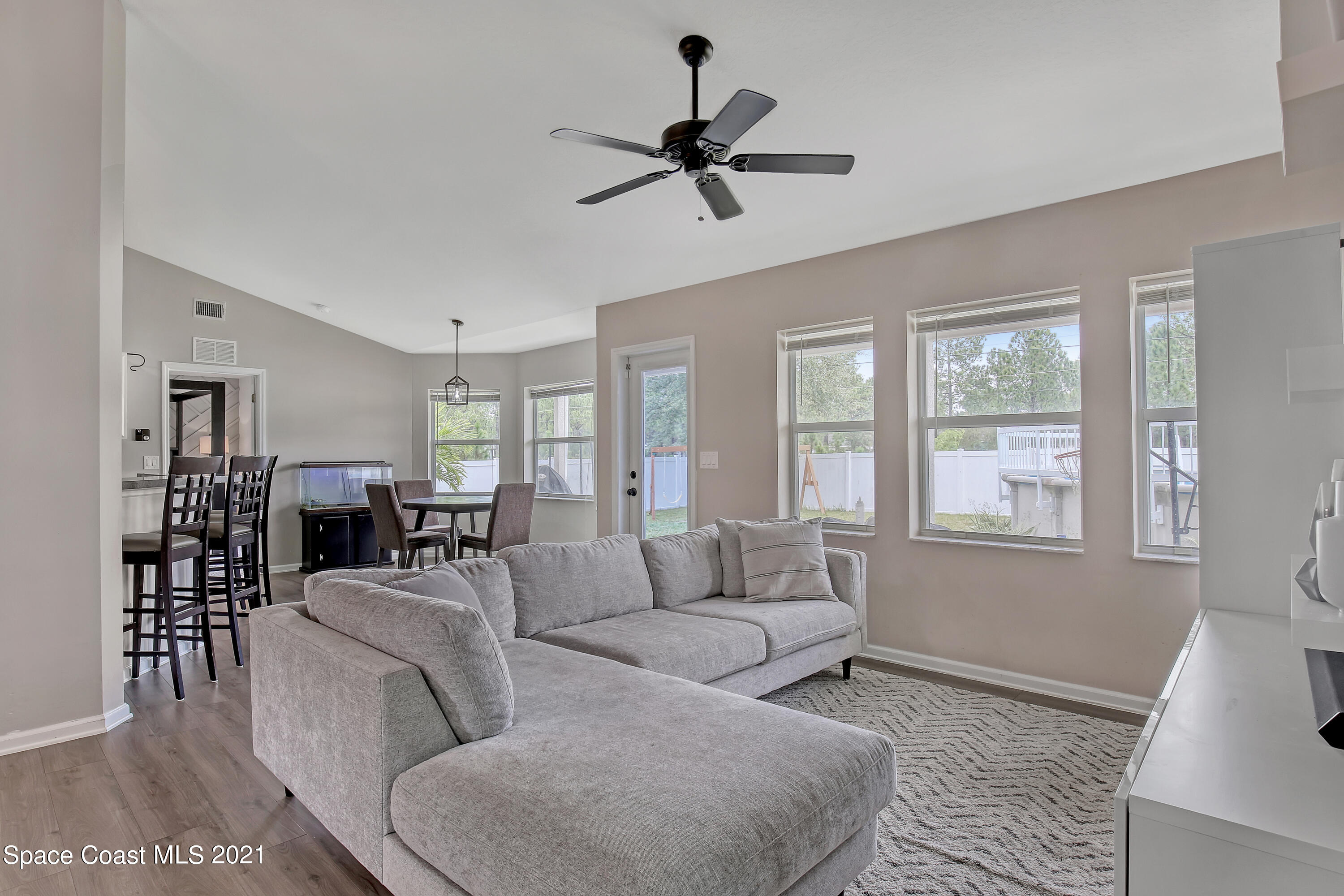 1277 Harlingen Road Southwest Palm Bay, FL 32908 - Photo 5 of 32 a living room with furniture a ceiling fan and a window
