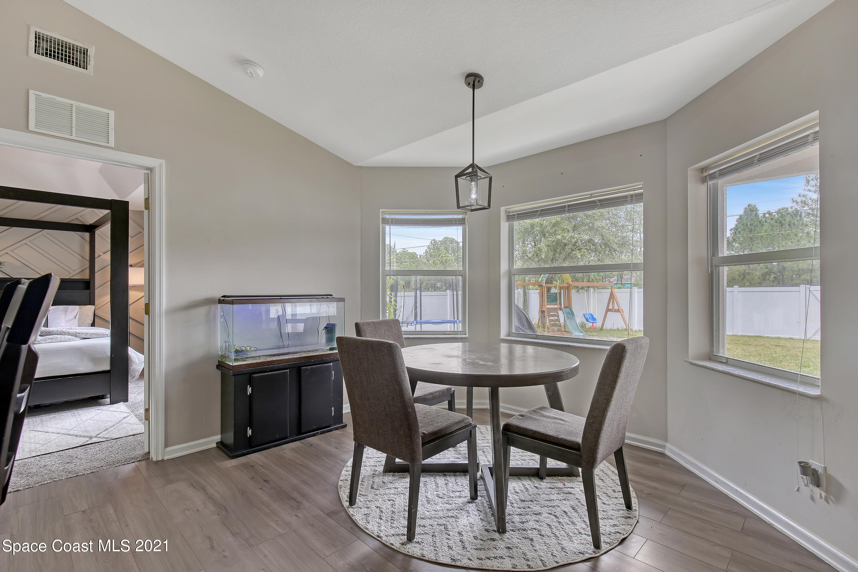 1277 Harlingen Road Southwest Palm Bay, FL 32908 - Photo 8 of 32 a view of a dining room with furniture window and wooden floor