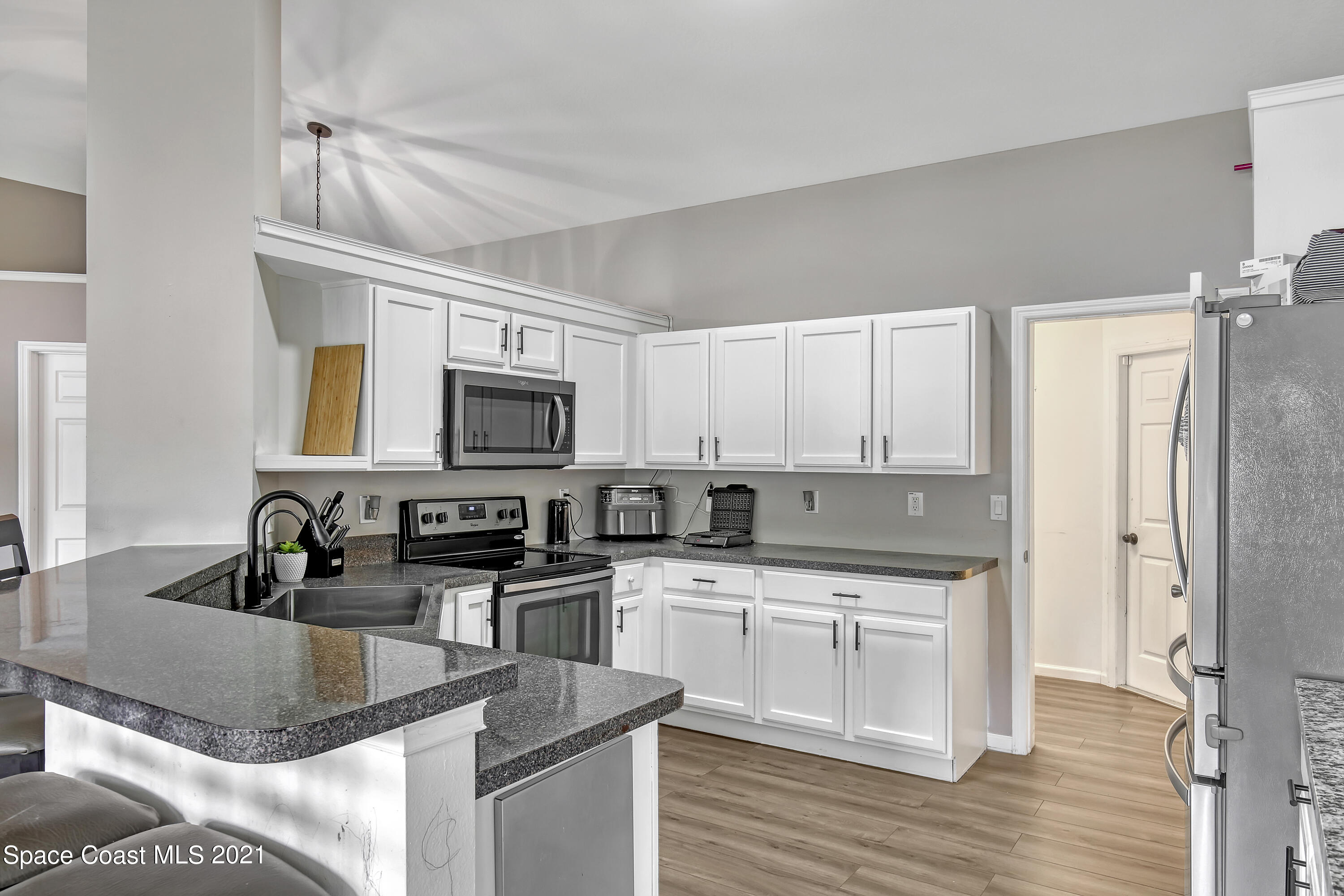 1277 Harlingen Road Southwest Palm Bay, FL 32908 - Photo 10 of 32 a kitchen with stainless steel appliances granite countertop a sink stove and refrigerator