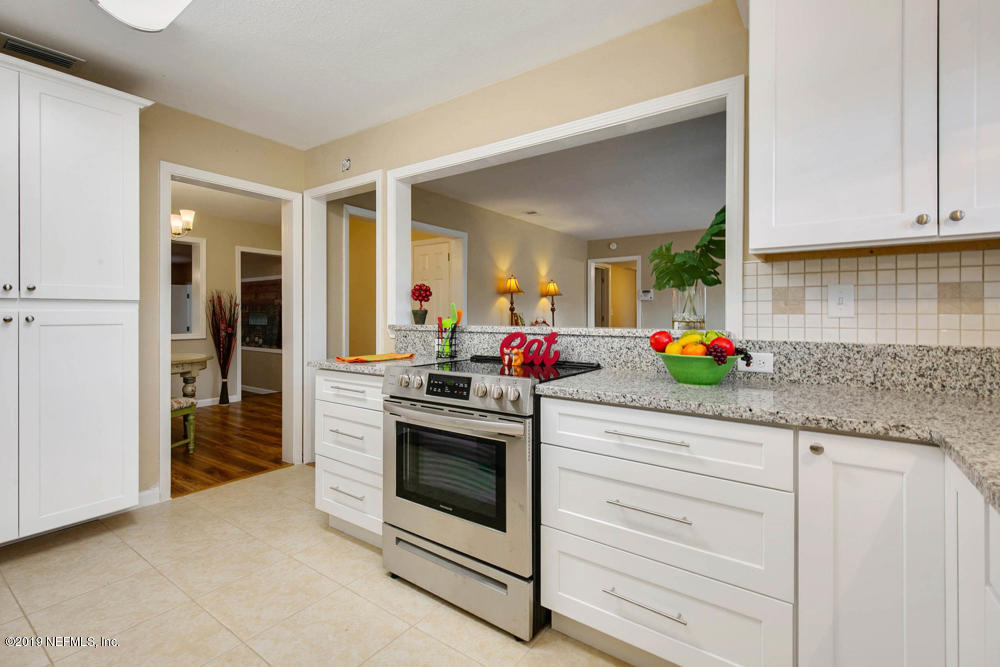 1175 Nightingale Road Jacksonville, FL 32216 - Photo 10 of 35 a kitchen with granite countertop white cabinets and white appliances