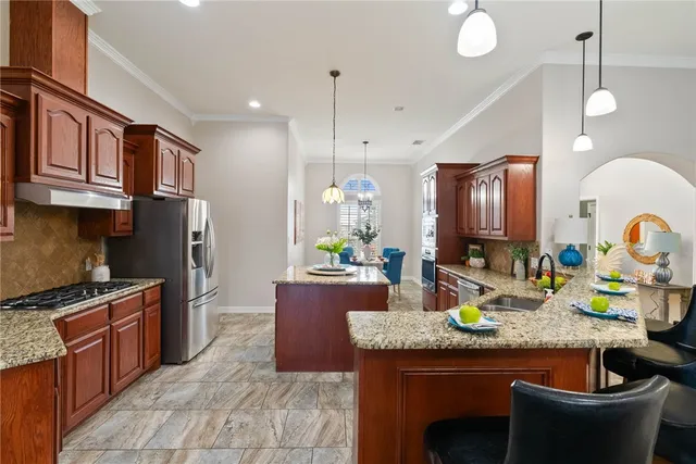 a kitchen with granite countertop a sink a stove and a wooden cabinets