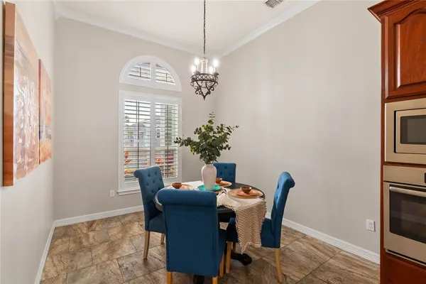 a dining room with furniture a chandelier and window