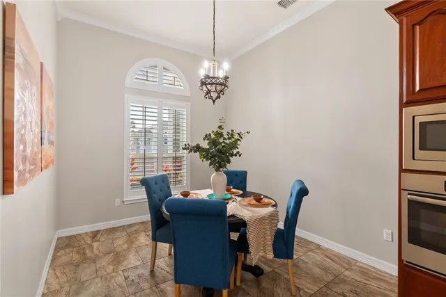 a dining room with furniture a chandelier and window