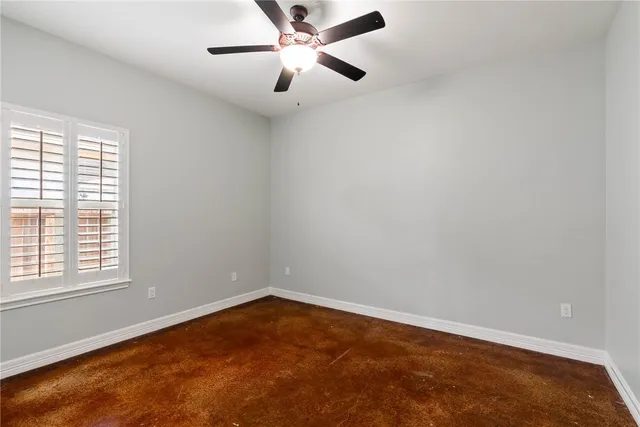 an empty room with a window and a fan